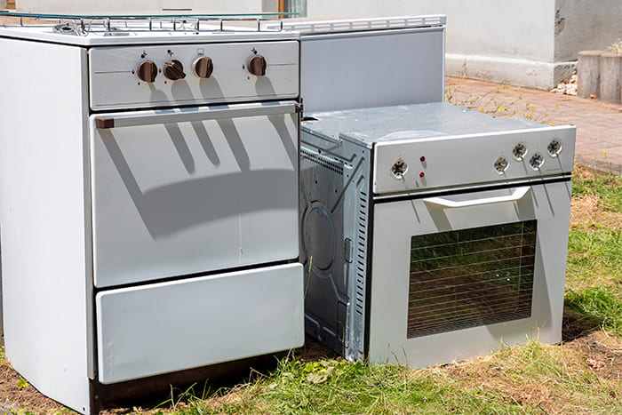 Zwei ausrangierte Elektroherde auf einer Wiese, bereit zur Abholung und fachgerechten Entsorgung.