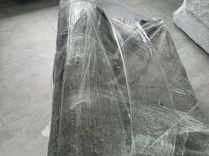 Ein Sofa, sorgfältig mit transparenter Schutzfolie umwickelt, bereit für den Transport