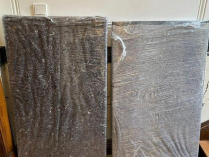 Zwei Polsterteile, sorgfältig mit Schutzdecke und transparenter Folie umhüllt, bereit für den Umzug