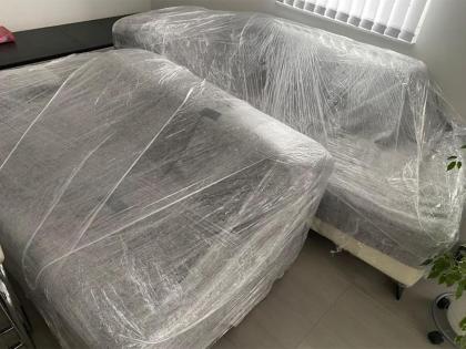 Zwei Sofas, sorgfältig mit transparenter Schutzfolie umhüllt, bereit für den sicheren Transport